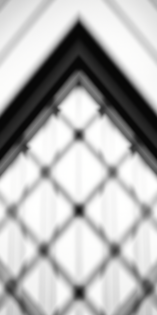 Generate an abstract black and white geometric design with a soft focus effect, shot with a Canon EOS R5, 50mm f/1.2 lens, aperture set to f/2.8, ISO 100, and a shallow depth of field to enhance contrast and detail.