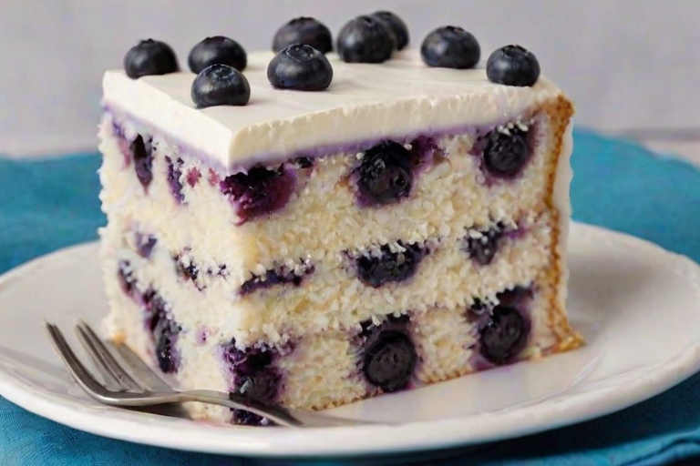 Create an image of a slice of layered blueberry cake with a creamy frosting on top. The cake should have vibrant purple layers filled with blueberries and a smooth white filling. Include a few fresh blueberries on top of the frosting and place the slice on a white plate with a fork beside it. The background should be simple and light to emphasize the cake.