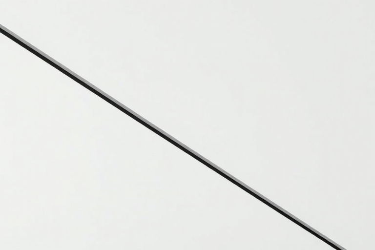 Create a high-contrast minimalist image of two diagonal lines on a plain background, captured with a Canon EOS R5 at f/8, ISO 100, 1/200s, top-down view, using a macro lens to enhance clarity and detail.
