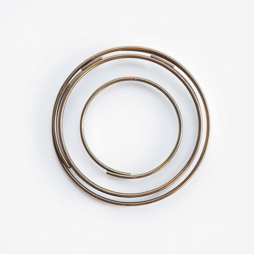 Generate a high-resolution image of a stylized spiral metal coil on a plain background, using a DSLR camera with a 50mm lens, f/1.8 aperture, ISO 100, shot in natural light from a top-down view to enhance detail and clarity.