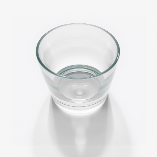 Generate a high-quality image of a transparent glass cup on a white background with a soft shadow beneath it, using a DSLR camera with a 50mm lens, aperture set to f/2.8, ISO 100, and a shutter speed of 1/125 sec, shot from a slight overhead angle to capture reflections and highlights.