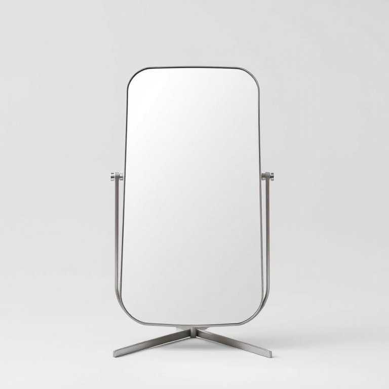 Create a high-resolution image of a standing mirror with a minimalist design, shot from a frontal view at a low angle, using a DSLR camera with a 50mm lens, aperture set to f/2.8, ISO 100, and a shutter speed of 1/200s, ensuring even lighting and a clean background.