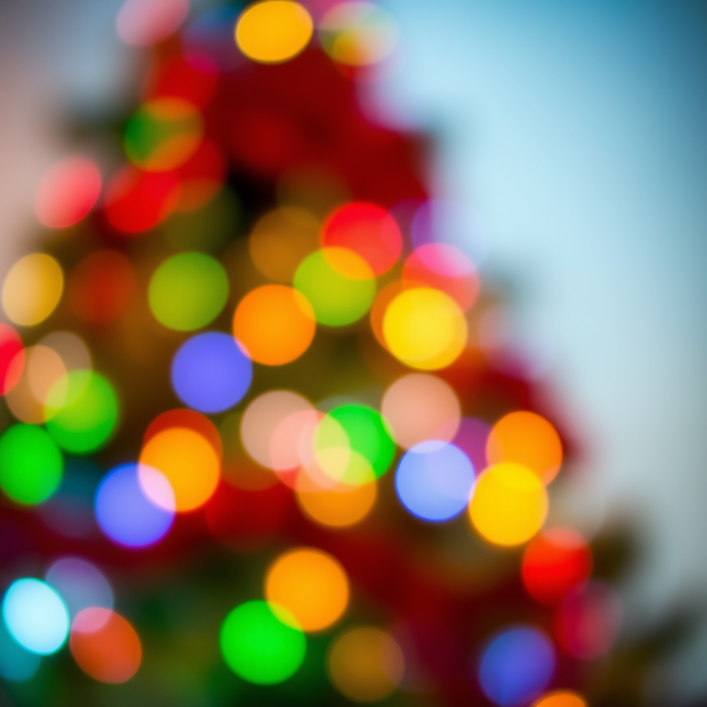 Create an abstract image of a softly blurred Christmas tree with colorful lights in various shades of red, green, blue, and yellow, creating a warm and festive atmosphere. The background should suggest a cozy holiday setting with a gentle bokeh effect.