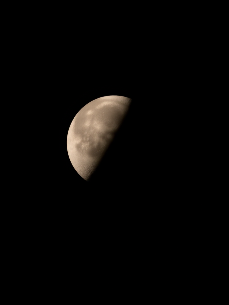 Capture a high-resolution image of a half moon against a black background using a Canon EOS 5D Mark IV, 300mm lens, f/8 aperture, ISO 200, with a 1/250 sec shutter speed and using a tripod for stability.