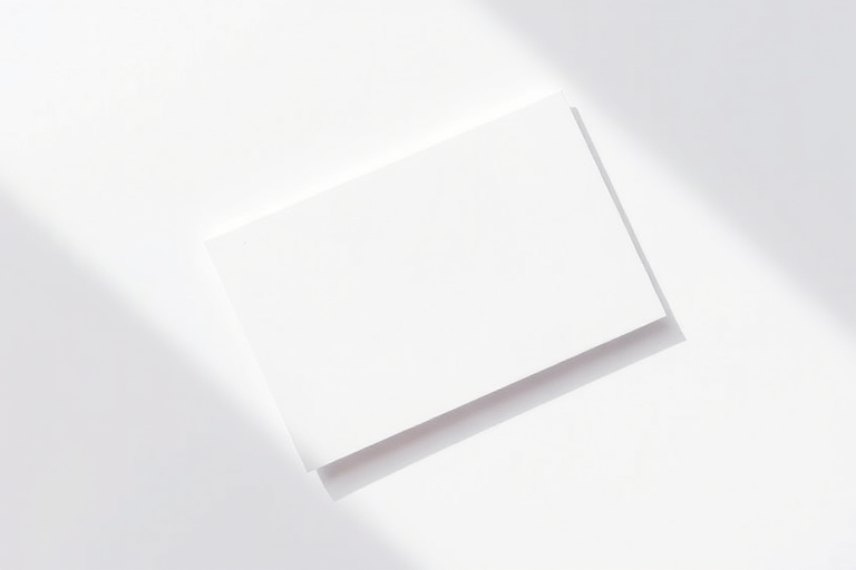 Create a high-resolution image of a blank index card lying diagonally on a white background, using a DSLR camera with a 50mm lens, aperture f/2.8, ISO 200, and a soft natural light to enhance shadows and texture.