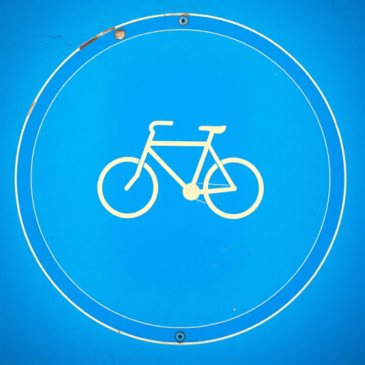 create a vivid image of a bicycle symbol on a circular blue background, using a DSLR camera with a 50mm lens, aperture set at f/8, ISO 100, and a shallow depth of field for enhanced clarity and contrast.