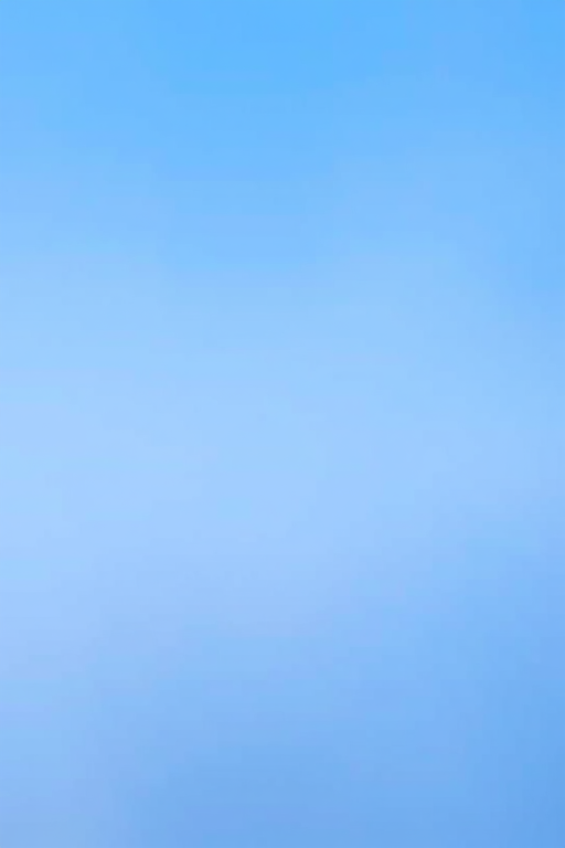Create a smooth gradient background transitioning from light blue at the top to darker blue at the bottom, using a Canon EOS R5 with a 50mm lens, aperture f/2.8, shutter speed 1/100 sec, ISO 100, shot in landscape orientation.