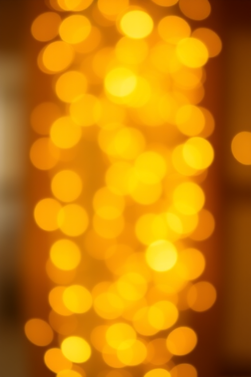 Create a vibrant golden bokeh background with sparkling lights, f/2.8 aperture, ISO 100, shutter speed 1/200 sec, taken from a slightly elevated angle, using a full-frame DSLR camera for enhanced image quality.