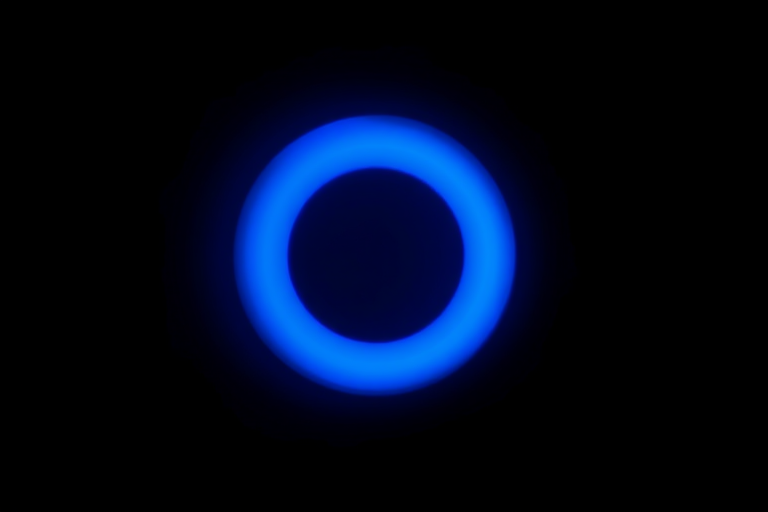 highly detailed digital art of a glowing blue circular light on a black background, emphasize luminosity and depth, shot with a Canon EOS R5, aperture f/2.8, ISO 100, 50mm lens, soft focus, long exposure effect for enhanced glow and smooth gradients