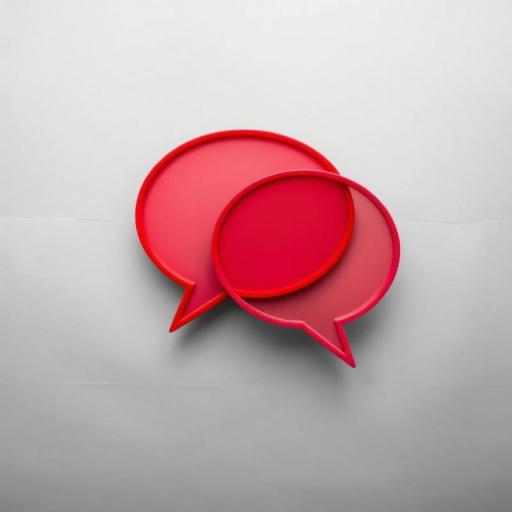 Create an image of two overlapping speech bubbles in vibrant red color, using a DSLR camera with a 50mm lens at f/1.8, capturing the bubbles from a slightly elevated angle against a monochromatic background to emphasize their shape and color.