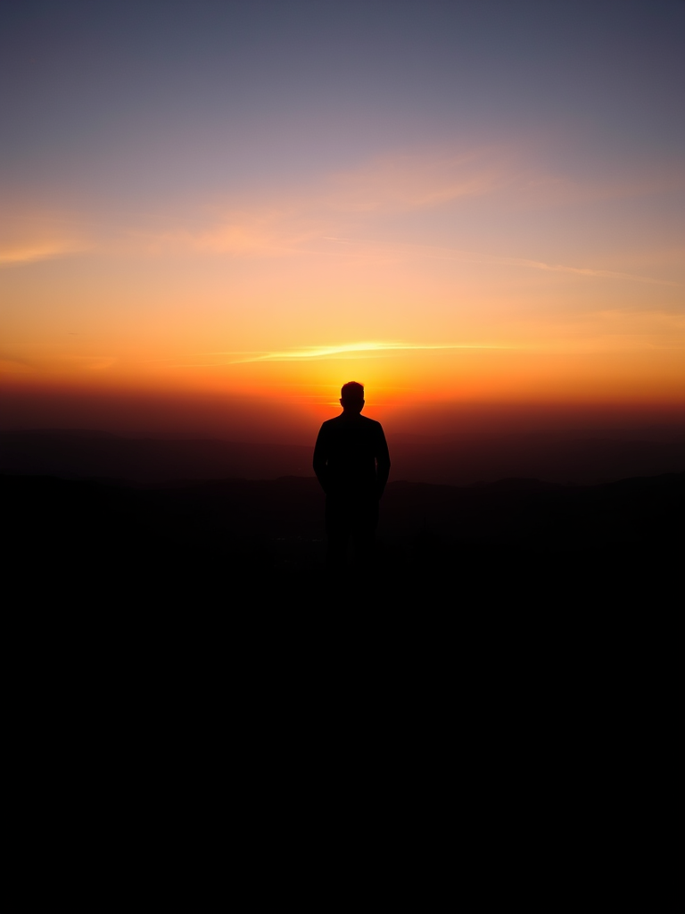 Create a high-resolution image of a silhouette of a person standing on a hilltop against a sunset background, using a DSLR camera with a 35mm lens at f/8 aperture, ISO 100, shutter speed 1/125 seconds, with a wide-angle view to capture the expansive sky and landscape, in a vibrant color style.