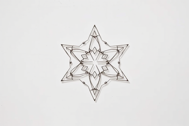 Generate an image of a geometric star made of interconnected hexagons, using a DSLR camera with a 50mm lens, aperture set to f/8, ISO 100, shot in natural lighting from a top-down view, with a clean and minimalistic background for clarity.