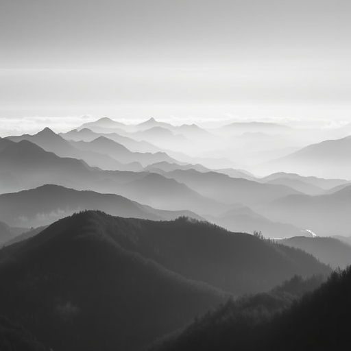 Regenerate a serene black and white landscape of misty mountains with soft gradients, captured with a full-frame DSLR camera at ISO 100, f/8 aperture, 24mm focal length, using a long exposure of 1/125 seconds, in a wide-angle view to emphasize depth and scale.