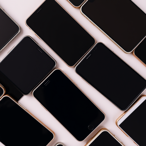 high-quality image of multiple smartphones with blank screens arranged in a dynamic pattern, shot with a DSLR camera using a 50mm lens, aperture f/1.8, shutter speed 1/200s, ISO 100, overhead view, soft lighting to minimize shadows