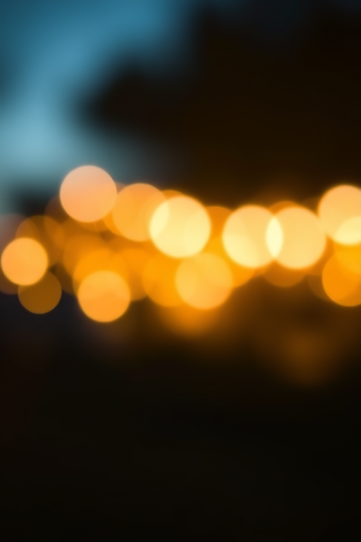 Create a bright, shimmering bokeh effect with golden and blue flecks in a soft-focus background, using a DSLR camera, 50mm lens, aperture f/1.8, ISO 100, with a wide-angle view and a warm color tone.