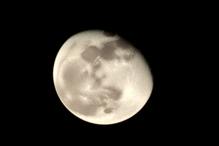 Capture a high-resolution image of a half moon against a black background using a Canon EOS 5D Mark IV, 300mm lens, f/8 aperture, ISO 200, with a 1/250 sec shutter speed and using a tripod for stability.