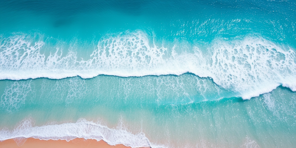 Aerial view of a tropical beach with turquoise waves gently lapping against the shore, bright sunlight illuminating the water, captured with a drone camera, f/4.0 aperture, ISO 100, 1/2000s shutter speed, using a wide-angle lens for enhanced clarity and depth.