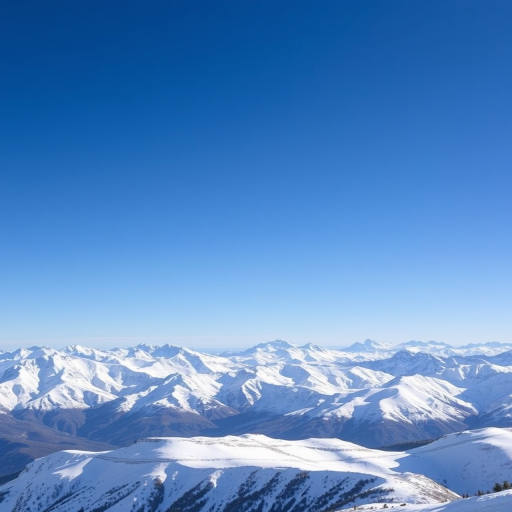Capture a breathtaking view of a snow-capped mountain range under a clear blue sky using a DSLR camera with a 24mm lens, aperture set to f/8, ISO 100, and a shutter speed of 1/200 seconds for crisp detail and vibrant colors.