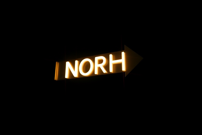 Create a high-resolution image of a 3D arrow pointing north, use a Canon EOS R5 camera, 50mm lens, aperture f/1.8, ISO 100, shot from a slight low angle with dramatic lighting to enhance the 3D effect.