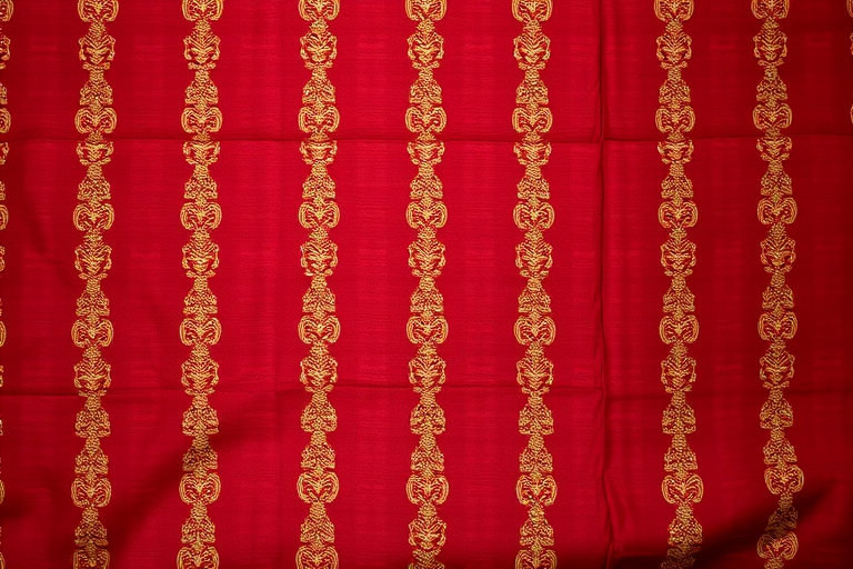 Create a richly textured fabric pattern featuring alternating vertical stripes of deep red and intricate gold detailing, shot with a Canon EOS 5D Mark IV, 50mm lens, f/1.8 aperture, ISO 100, natural light, top-down view for enhanced quality and clarity.