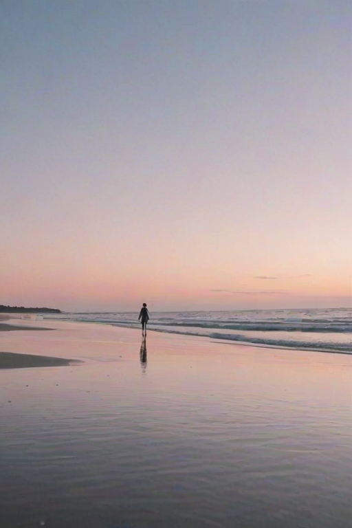 Soft-focus image of a quiet beach at twilight, with gentle waves lapping at the shore, soft pastel colors in the sky, and a single silhouette walking along the water’s edge.