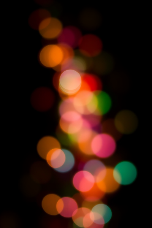 bokeh lights in vibrant colors against a black background, f/2.8 aperture, ISO 100, 50mm lens, shallow depth of field, DSLR camera, soft focus effect