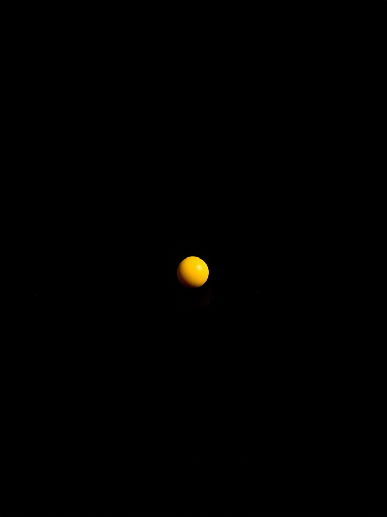Create a high-resolution image of a small yellow point on a black background, using a DSLR camera with a 50mm lens, f/1.8 aperture, ISO 100, and 1/200 sec shutter speed, in a macro view style for enhanced clarity and detail.