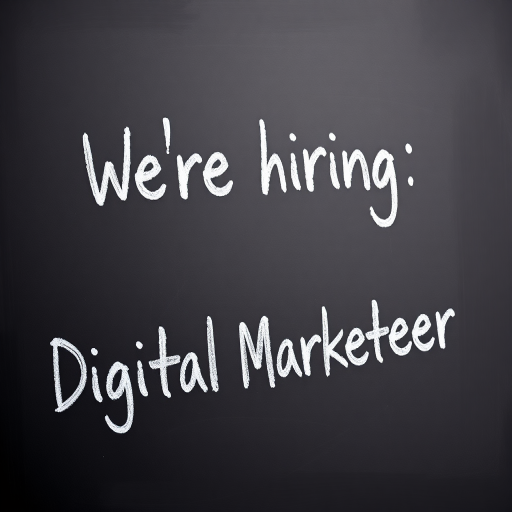 Create an image of a chalkboard with the text "We're hiring: Digital Marketeer" written in chalk, using a DSLR camera with a 50mm lens, f/1.8 aperture, ISO 200, 1/100s shutter speed, angled view for emphasis.