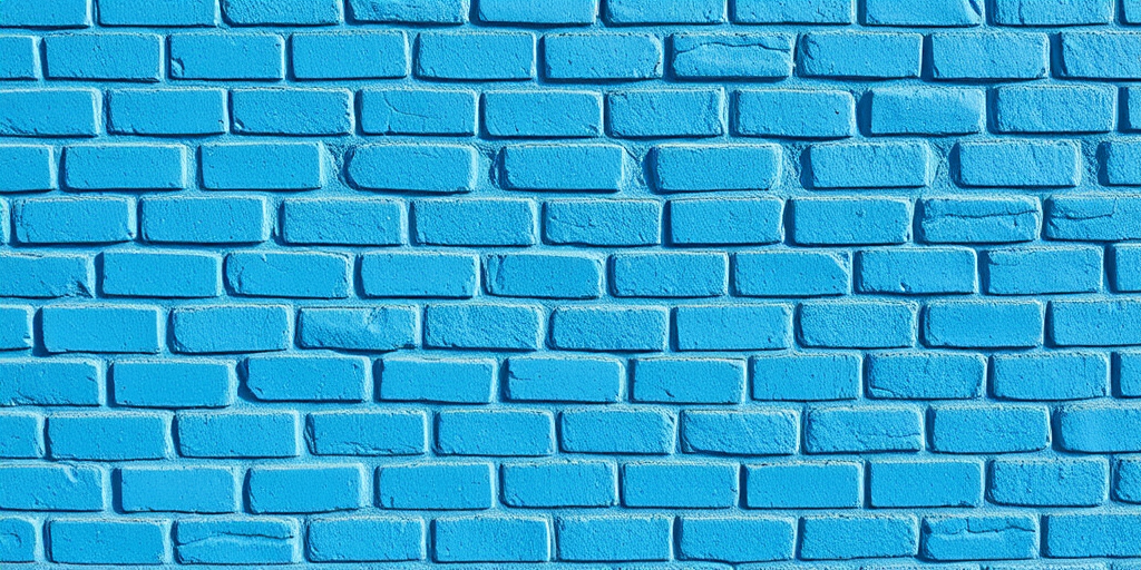 Create a high-resolution image of a textured blue brick wall, shot with a DSLR camera at f/8 aperture, ISO 100, and a shutter speed of 1/125s, using a straight-on view and natural daylight to enhance color vibrancy and detail.