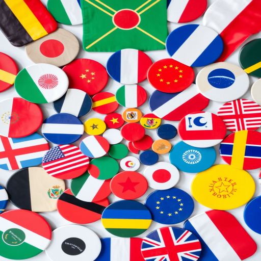 Create a vibrant flat lay composition of circular flags from various countries, using a DSLR camera with a 50mm lens at f/1.8, ISO 100, and a shallow depth of field to enhance colors and details, shot from a top-down perspective with natural lighting.