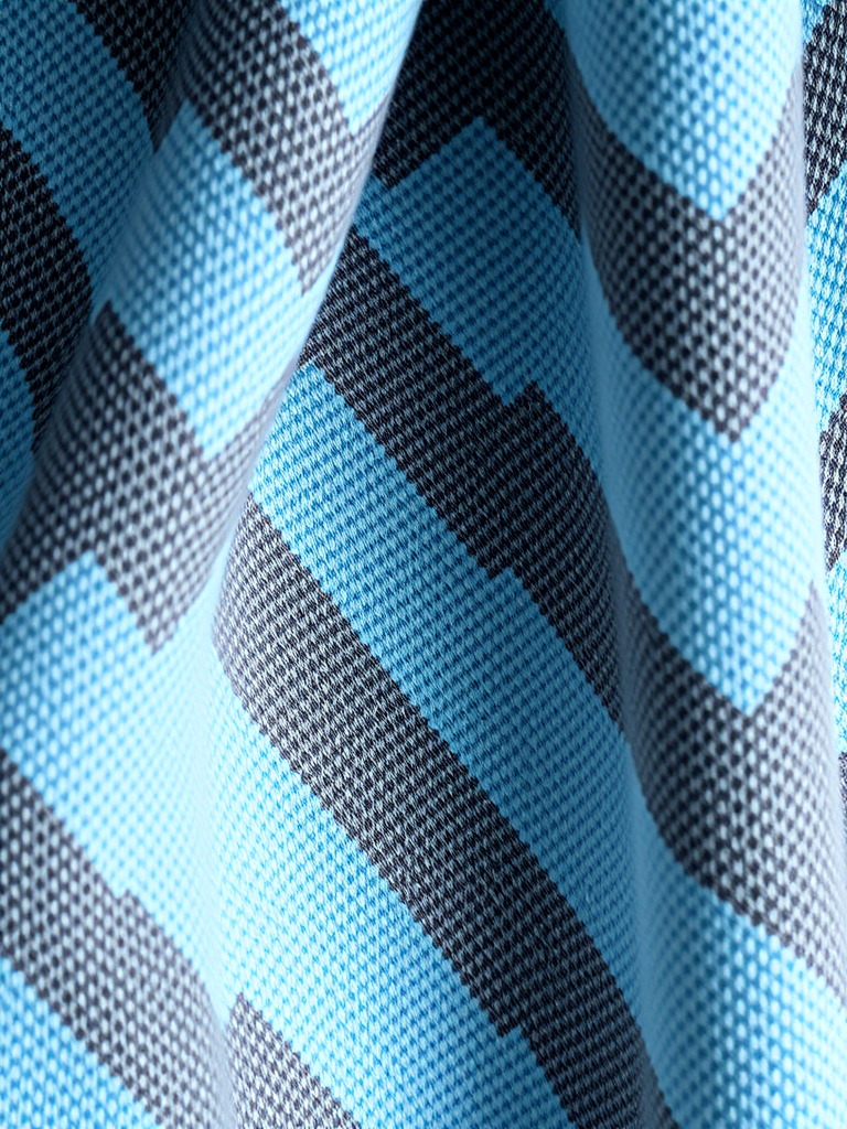 Create a high-resolution image of a textured fabric featuring a zigzag pattern in light blue and gray, shot with a Canon EOS R5 at f/2.8, ISO 100, 50mm lens, in natural light for enhanced detail and depth.