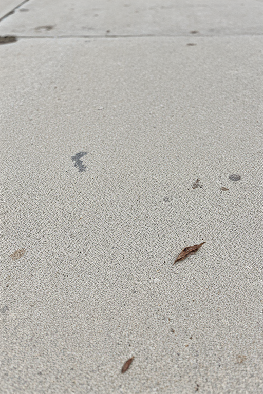 Capture a high-resolution texture image of a weathered concrete surface, using a DSLR camera with a 50mm lens, aperture set to f/8, ISO 100, and a focused depth of field from a slight angle to highlight imperfections and variations in color and texture.