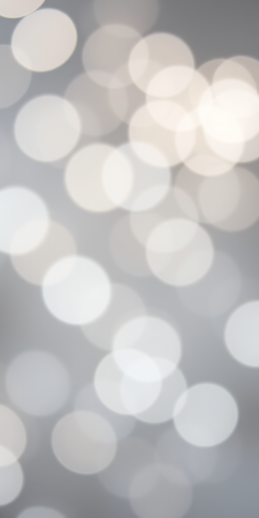 Create a high-resolution image of a soft-focus background with white bokeh circles on a gray background, use a 50mm lens at f/1.8, ISO 100, 1/200s shutter speed, taken from a close-up view with a DSLR camera for enhanced clarity and detail.