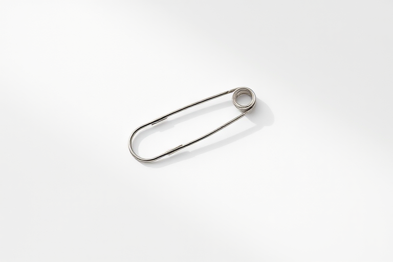 create a high-resolution image of a silver safety pin on a plain white background with soft lighting, using a DSLR camera, 50mm lens, f/2.8 aperture, ISO 100, 1/200 sec shutter speed, top-down view, shallow depth of field to enhance detail and focus on the pin