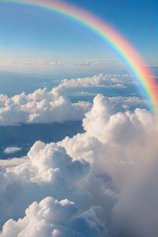 a vibrant rainbow arching across a light blue sky above fluffy white clouds with a smooth gradient of colors