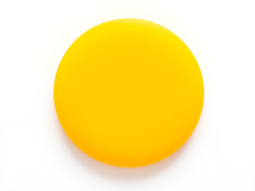 A bright yellow circular shape with a smooth texture on a plain white background, captured with a Canon EOS R5, aperture f/2.8, ISO 100, 50mm lens, macro view, natural lighting.