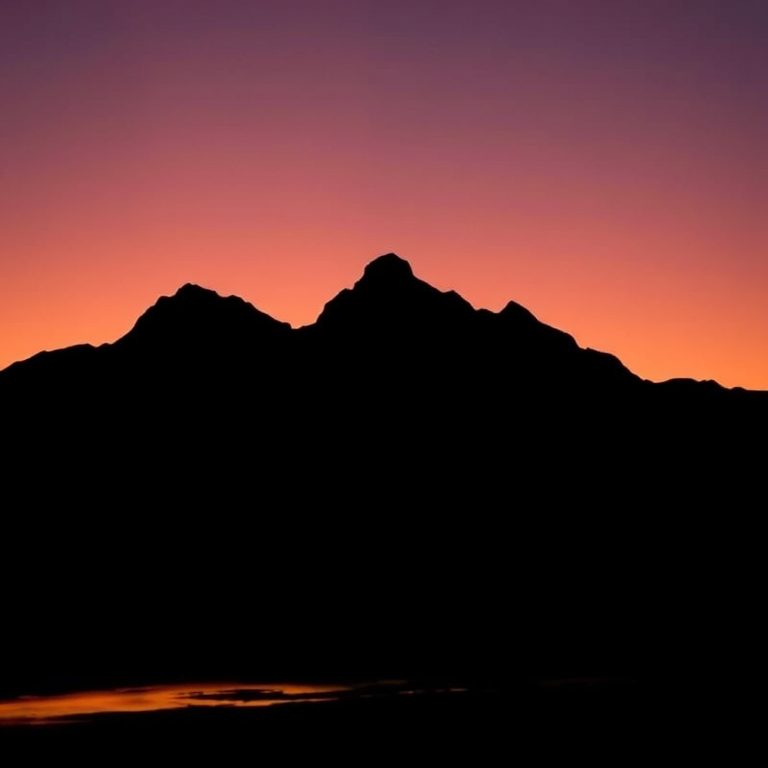 Create a minimalistic black silhouette of a mountain landscape during sunset, capturing warm colors in the sky, using a DSLR camera with a 50mm lens, aperture set to f/2.8, ISO 100, and a shutter speed of 1/125s, shot from a low angle for dramatic effect.