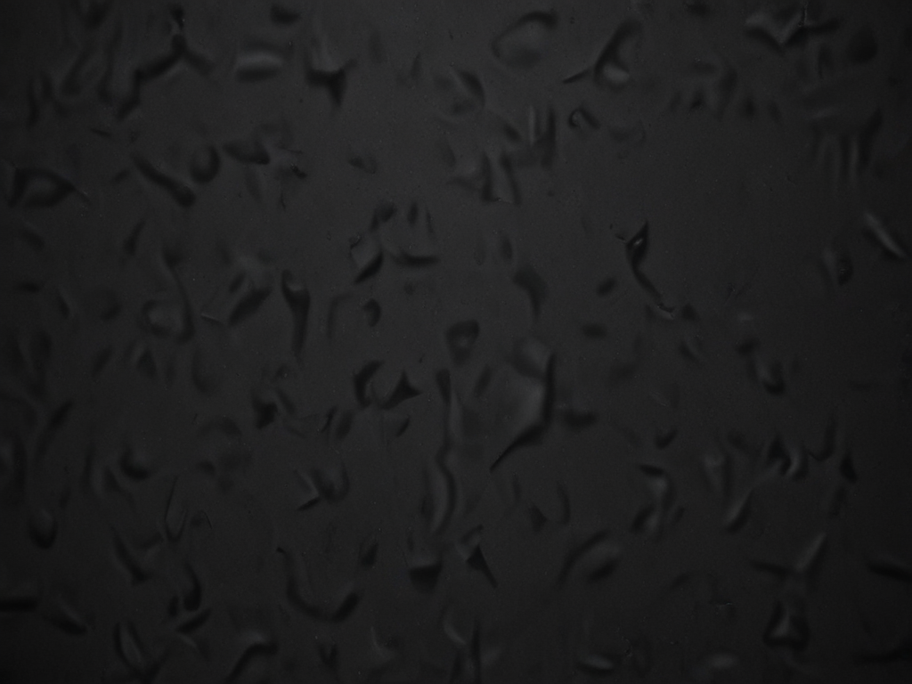 Textured Black Surface with Subtle Patterns and Depth in Shadows
