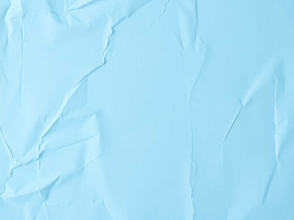 Generate an image of a wrinkled light blue paper background, soft focus, 50mm lens, f/2.8 aperture, ISO 100, top-down view, DSLR camera, natural lighting.