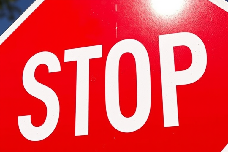 Create an image of a stop sign with a clear red background and bold white text, using a DSLR camera with a 50mm lens at f/2.8 aperture, ISO 100, and a shallow depth of field to enhance brightness and focus, captured from a slightly low angle to emphasize the sign.