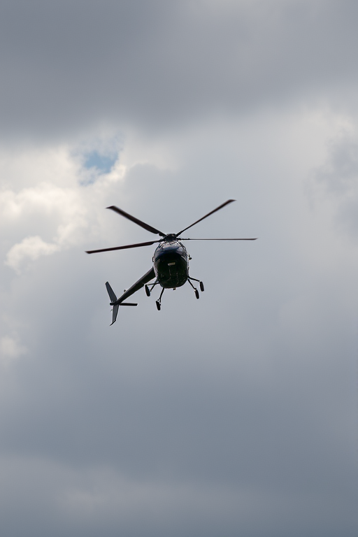 helicopter flying against a cloudy sky, shot with a DSLR camera at 1/500 sec, f/8, ISO 200, 50mm lens, aerial view, high-resolution
