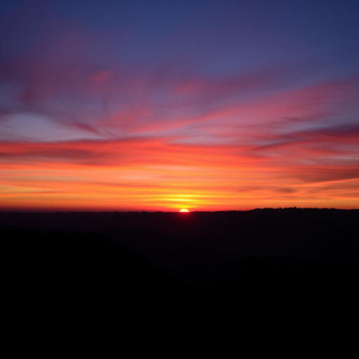 Capture a high-resolution image of a vibrant sunset over a silhouette of mountains, taken with a DSLR camera at f/8 aperture, ISO 100, and a 24mm focal length, using a landscape orientation and soft lighting to enhance colors and contrast.