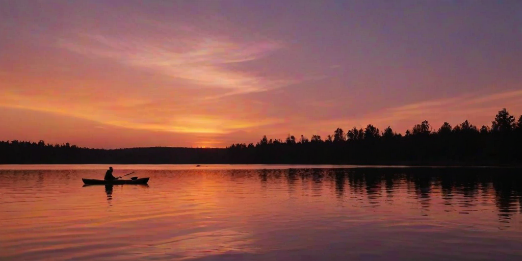 Beautiful sunset over a tranquil lake, with a silhouette of a couple kayaking, the sky ablaze with oranges and purples, creating a romantic and peaceful atmosphere.