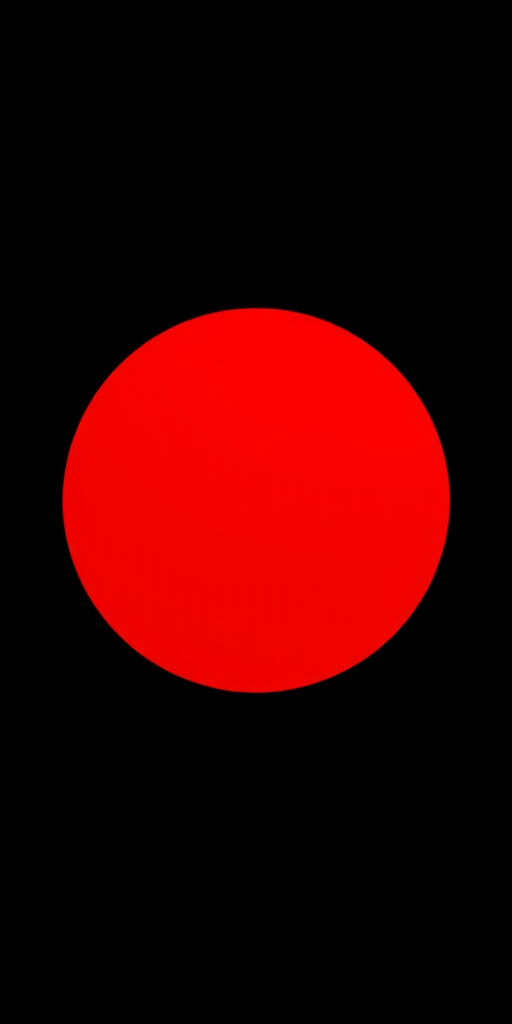 Create a bright, glossy red circle centered in a minimalist black background using a DSLR camera with a 50mm lens at f/1.8 for shallow depth of field, ISO 100, and a soft diffused light source to enhance reflections.