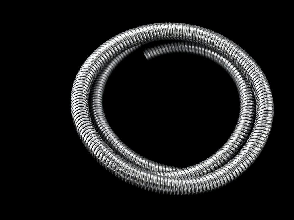 A high-resolution image of a coiled stainless steel shower hose against a plain black background, taken with a DSLR camera at f/8 aperture, 1/125 shutter speed, ISO 100, using a macro lens for sharp detail and soft background blur.