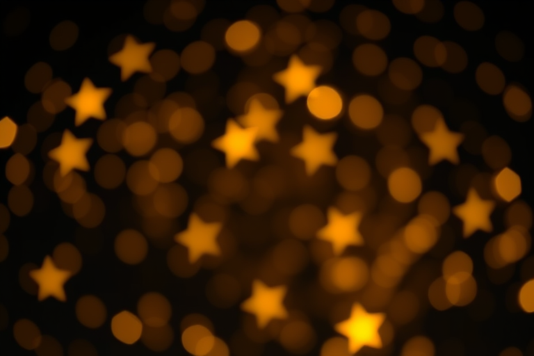 Create an enchanting scene of shimmering golden stars on a rich black background with a bokeh effect, using a DSLR camera with a 50mm lens, f/1.8 aperture, ISO 100, and a shallow depth of field to enhance the glow and details of the stars.