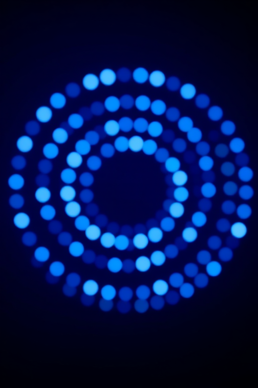 Generate a high-resolution abstract image of concentric circles with glowing blue lights against a dark blue background, use a wide-angle lens with an aperture of f/2.8, ISO 100, and a shutter speed of 1/60s, captured with a full-frame DSLR camera for enhanced clarity and depth.