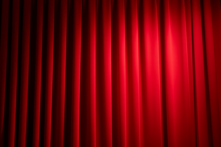 Create a high-resolution image of a stage curtain in deep red, shot with a DSLR camera at f/2.8 aperture, ISO 100, 50mm lens, with a shallow depth of field focusing on the texture of the fabric, bright lighting to enhance colors and create depth.