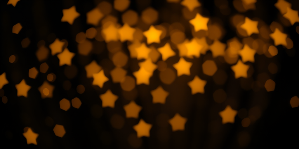 Create an enchanting scene of shimmering golden stars on a rich black background with a bokeh effect, using a DSLR camera with a 50mm lens, f/1.8 aperture, ISO 100, and a shallow depth of field to enhance the glow and details of the stars.