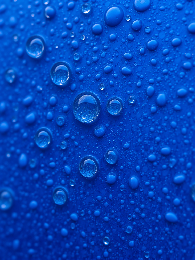 Generate a close-up image of a textured blue surface with water droplets on it, macro lens, f/2.8 aperture, ISO 100, shutter speed 1/200s, natural lighting, DSLR camera.